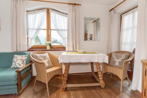 a dining room with a table and chairs and a window at Gästehaus Bergstüberl in Reit im Winkl