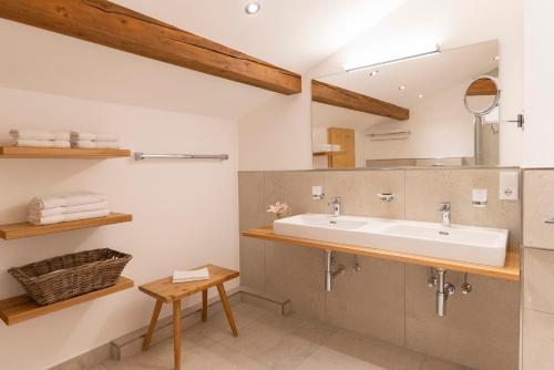 ein Bad mit einem Waschbecken und einem Spiegel in der Unterkunft Gästehaus Bergstüberl in Reit im Winkl