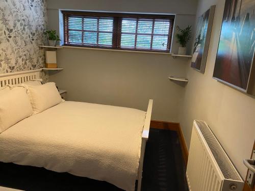 a small bedroom with a bed and a window at Kings Arms Annex in Steventon