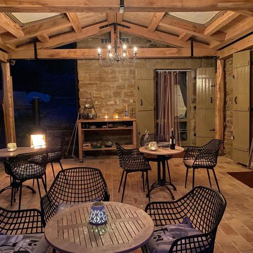 un patio con mesas y sillas y una chimenea en Casa Al Fondo, en Gualdo di Macerata