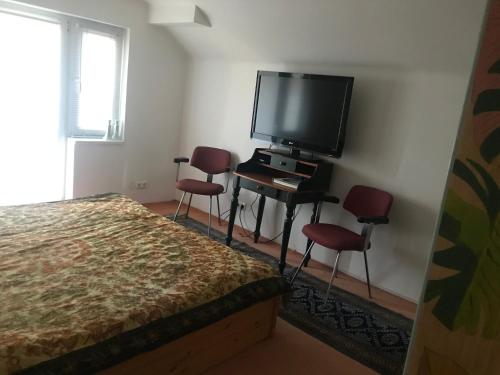 a bedroom with a bed and a flat screen tv at Bei Annerl in Gmunden
