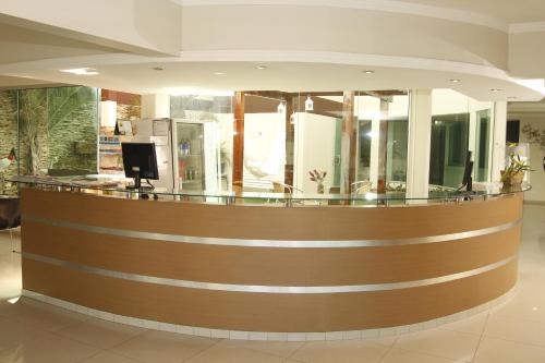 a large lobby with a brown and glass counter at Turis Hotel Centro in Campo Grande