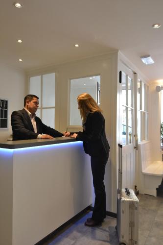 a woman standing next to a man at a counter at Hotel St. Gervais in Geneva