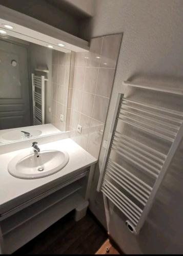 une salle de bain avec un lavabo et un miroir dans l'établissement Le hameau des écrins, à Narreyroux