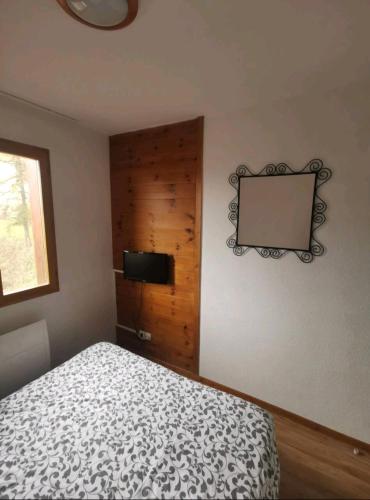 une chambre avec un lit et une télévision à écran plat dans l'établissement Le hameau des écrins, à Narreyroux