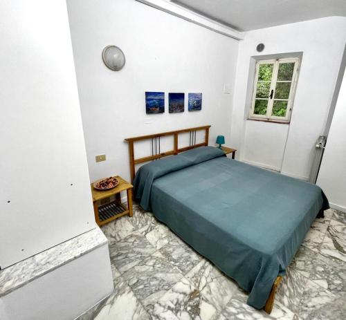 - une chambre blanche avec un lit dans l'établissement Appartamento Bocca di Magra, à Bocca di Magra