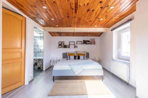 une chambre avec un lit avec un plafond en bois dans l'établissement La Maisonnette - Confort & Calme, à Lezoux