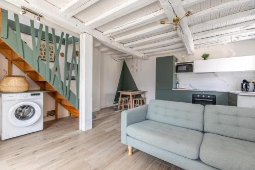 un salon avec un canapé et un escalier dans l'établissement La Maisonnette - Confort & Calme, à Lezoux