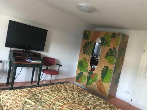 a room with a desk and a television and a chair at Bei Annerl in Gmunden