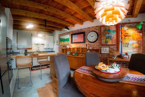 a kitchen and dining room with a clock on the wall at Alilandia - Casa Vacanza in Valdobbiadene