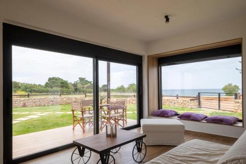 a living room with large windows and a view of the ocean at OLIVOMARE in Kyparissia
