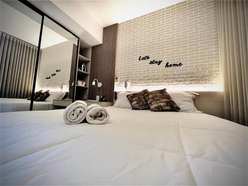 a bedroom with a large white bed with towels on it at Conforto no melhor do Marista & Goiânia in Goiânia