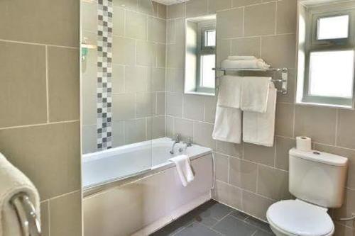 a bathroom with a tub and a toilet and a sink at Zaib Guest House for Families Only in E-11 Islamabad in Islamabad
