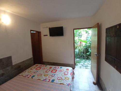 ein Schlafzimmer mit einem Bett und einem TV an der Wand in der Unterkunft Casaione in Puerto Colombia