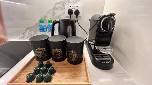 a kitchen counter with a blender and cups on a cutting board at 1-Bed Loft with Pool View in Abu Dhabi