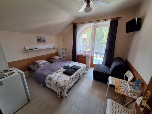 Un dormitorio con una cama y un sofá y una ventana. en Vila ETIJA, en Veľký Meder