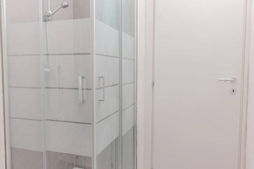 a shower with a glass door in a bathroom at Staurenghi Green Apartment in Varese