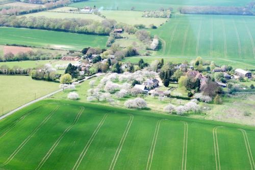 an aerial view of a house in a green field at Frith Farm House Cottages in Newnham