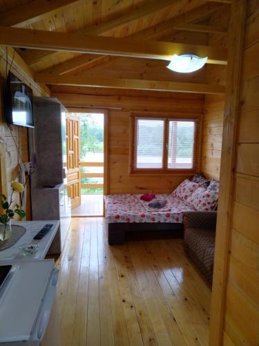 een kamer met een bed in een houten hut bij Slatka Drina in Lazarevići