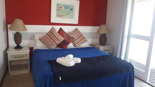 a bedroom with a blue bed with towels on it at Porto Mar de Búzios in Búzios