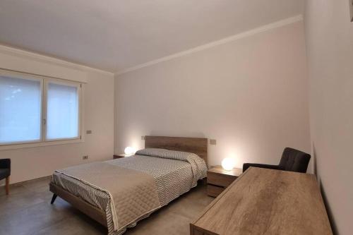 um quarto com uma cama, uma mesa e uma janela em Villa Katy em Tormine
