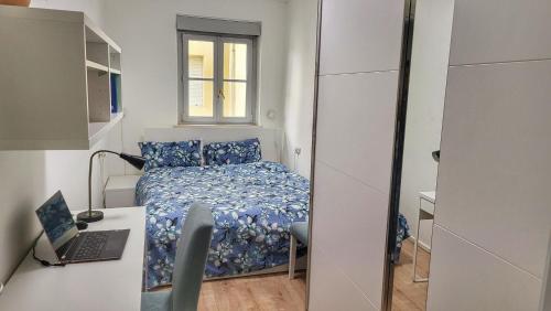 um pequeno quarto com uma cama e uma secretária com um computador portátil em Dolomiti 2 rooms Apartment Center WiFi TVsmart AC em Bolzano