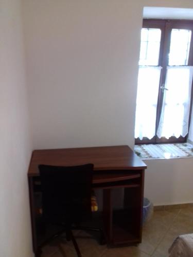 a desk with a chair in a room with a window at ΠΗΛΙΟ- ΤΟ ΕΞΟΧΙΚΟ ΤΗΣ ΑΝΝΑΣ- ΑΦΗΣΣΟΣ in Afissos