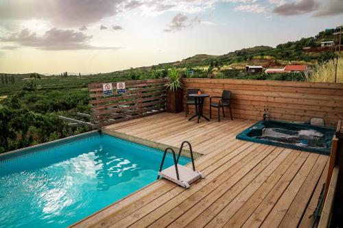 a deck with a plunge pool and a table on a wooden deck at Aurora Golan in Buq‘ātā