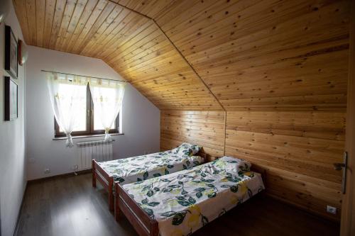 1 Schlafzimmer mit 2 Betten und Holzdecke in der Unterkunft OSTOJA RYCERSKA 