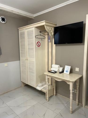 a room with a desk and a flat screen tv at Budget Family Hotel in Lviv