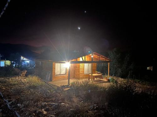 una cabaña de madera por la noche con la luz encendida en Cabañas Freirina, en Freirina