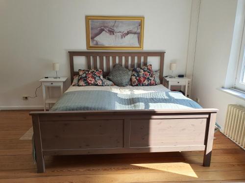 a bedroom with a large wooden bed with pillows at Wohnen in der Bürgermeistervilla in Hamburg