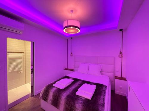 een paarse kamer met een bed met paarse verlichting bij loft romantique spa in Nice