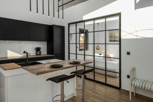 a kitchen with black cabinets and a counter with stools at OLIVOMARE in Kyparissia