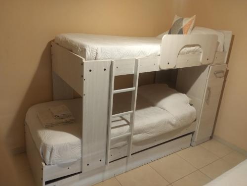 メンドーサにあるDepartamento Mendozaの白い二段ベッドが備わる客室です。