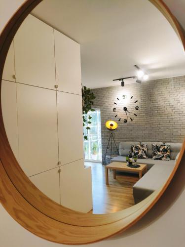 a circular mirror in a living room with a couch and a table at Apartament Radio Tower in Gliwice