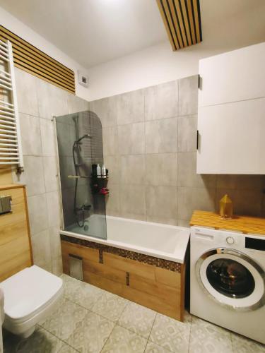 a bathroom with a toilet and a washing machine at Apartament Radio Tower in Gliwice