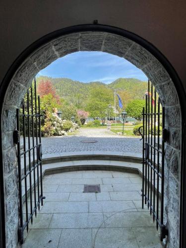 an archway with a view of a park from a garden at Hotel Maier zum Kirschner in Rottach-Egern