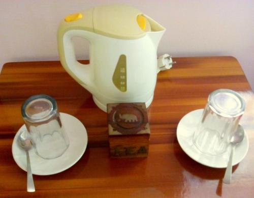 a tea pot and two glasses on a table at Namaste Yoga Farm in Gokarna