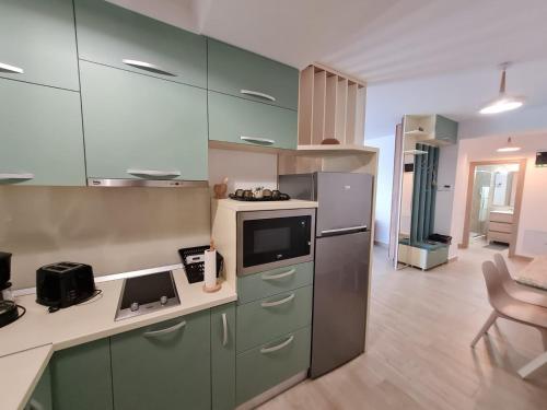 a kitchen with green cabinets and a white counter top at Matteo 2 Apartments Marina Surf Residence, Mamaia Nord - Năvodari,1 vedere frontala,2 cu vedere laterala la mare in Năvodari
