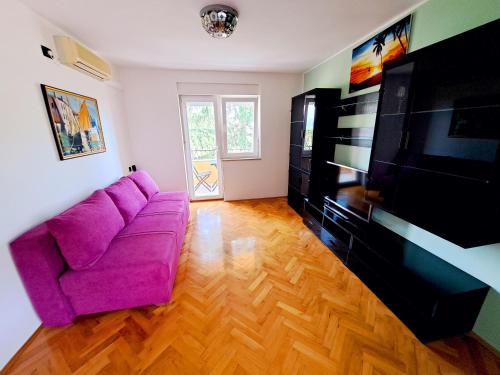 a living room with a purple couch and a tv at Apartman Koli Opatija in Opatija