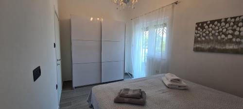 ein Schlafzimmer mit einem Bett mit zwei Handtüchern darauf in der Unterkunft Apartments Rajna in Čižići
