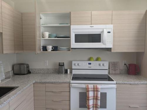 a kitchen with a white stove and a microwave at Harbison in Winnipeg