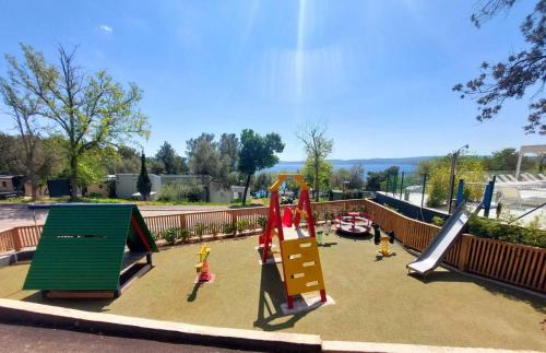 a playground with slides and play equipment in a park at Mobile Home Mar Vista Selce in Selce