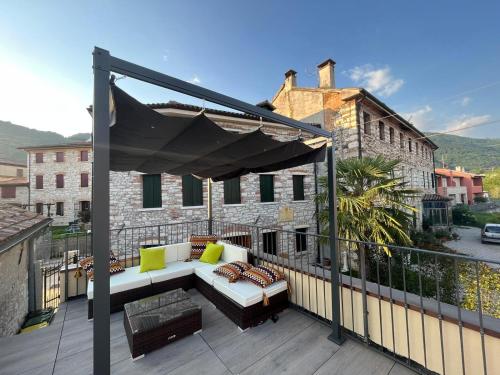 patio con sofá y balcón con dosel en Alilandia - Casa Vacanza, en Valdobbiadene