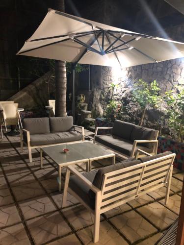 a patio with a table and chairs and an umbrella at Palazzo Vingius in Minori
