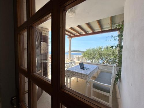 a window view of a table with a laptop on a balcony at Villa Porthos in Hvar