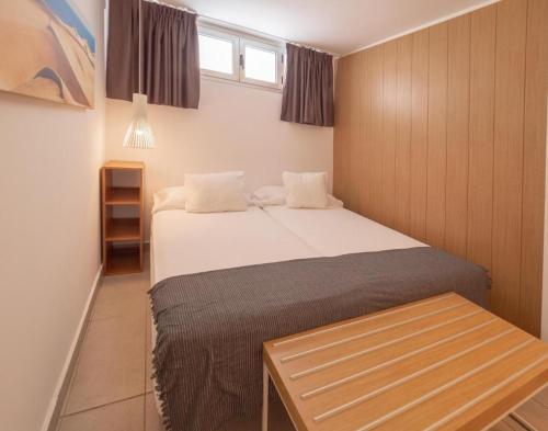 ein kleines Schlafzimmer mit einem Bett und einem Tisch in der Unterkunft Apartamento vacacional Bronze Playa 330 in San Bartolomé de Tirajana