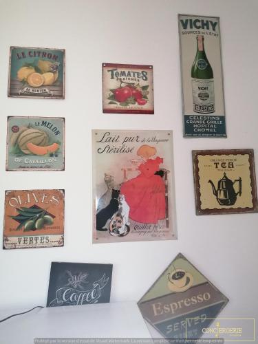 a wall with posters and signs on a wall at La villa de charmassone in Montfrin