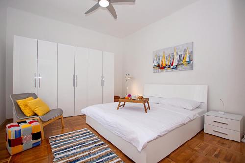 a bedroom with a bed with a table and a chair at Dinos Place in Zadar